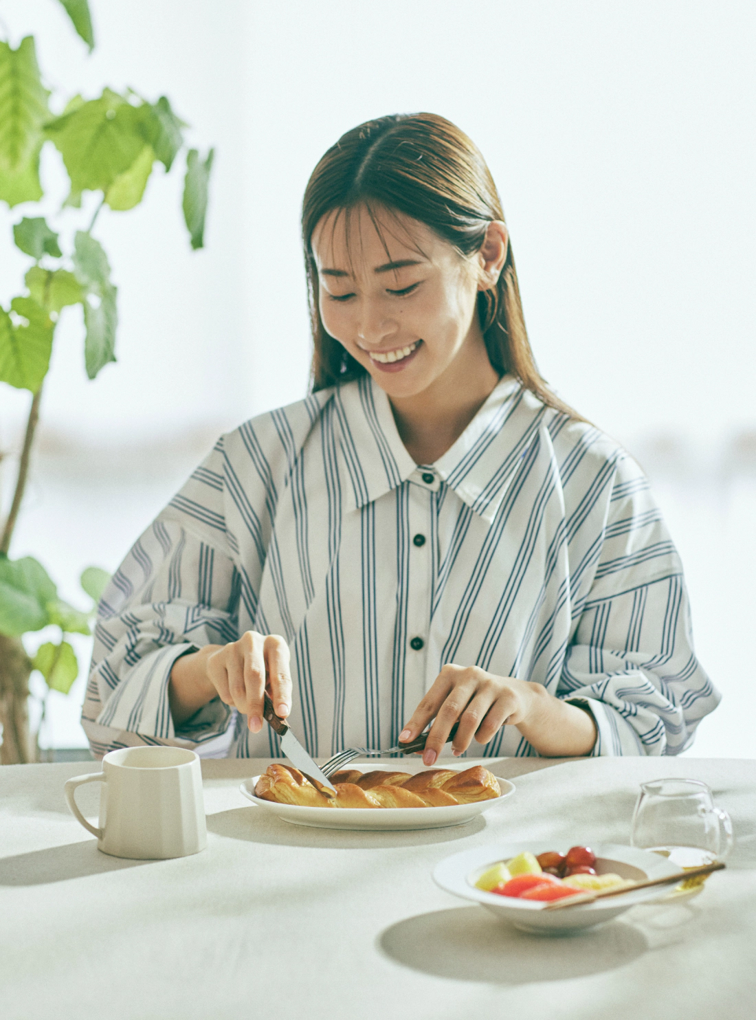 食パンにバターを塗る女性